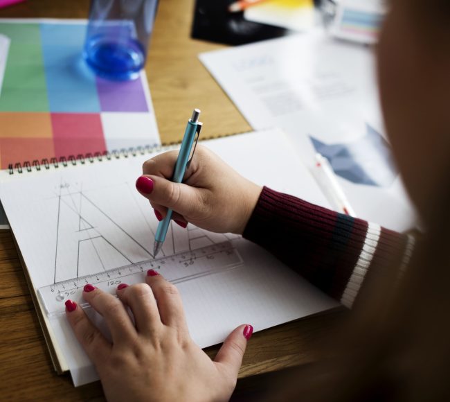 Caucasian female hands illustrating in a notebook